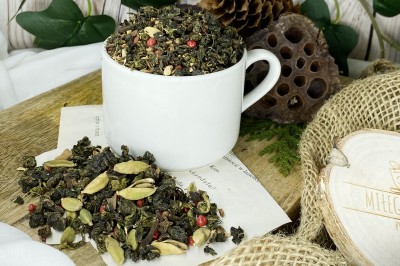 Niebieskozielone zwinięte liście herbaty oolong wymieszane z korą cynamonu imbirem kardamonem goździkami i ziarnami czerwonego pieprzu