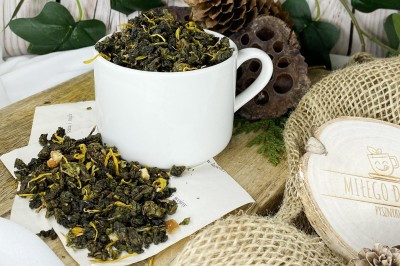 Ciemnozielone zwinięte liście herbaty oolong wymieszane z pomarańczową skórką żółtymi płatkami nagietka i kawałkami cynamonu