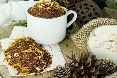 Słoneczne płatki nagietka oraz kawałki skórki pomarańczy w drobnych igiełkach herbaty rooibos
