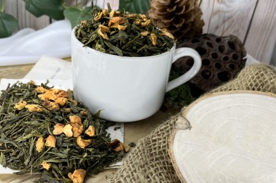 Jasnozielone podłużne liście herbaty Sencha połączone z jasnymi kostkami suszonego jabłka
