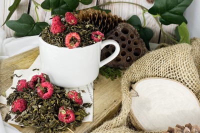 Charakterystyczne zwinięte w kulki liście herbaty Gunpowder z widocznymi kawałkami czerwonych malin i suszonymi liśćmi lipy