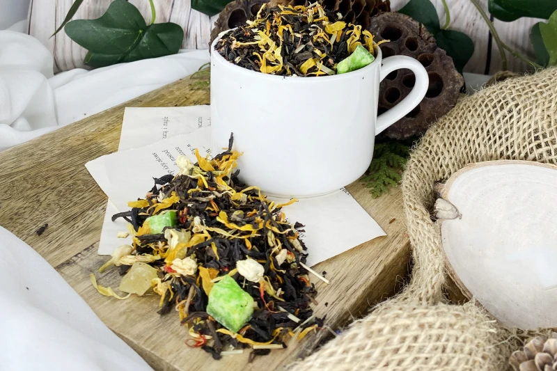 Ciemne liście czarnej herbaty wymieszane ze skórką pomarańczy kandyzowaną cytryną i mango trawą cytrynową jaśminem płatkami słonecznika oraz dzikiego szafranu
