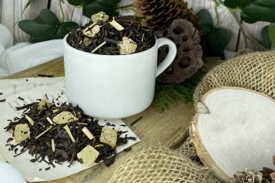 Ciemnobrązowe liście herbaty Pu-Erh z widocznymi żółtymi kostkami kandyzowanego ananasa i suszoną trawą cytrynową