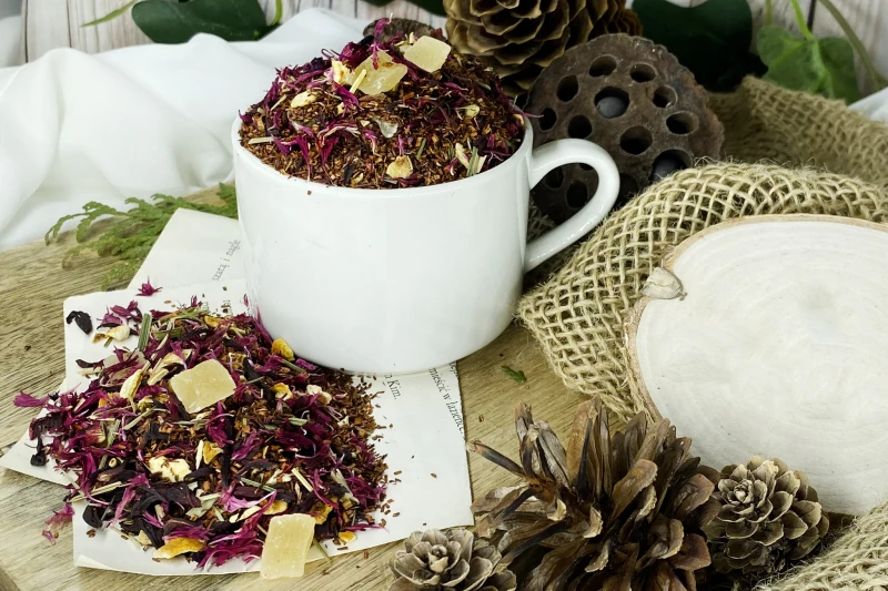Kostki ananasa paski trawy cytrynowej oraz płatki hibiskusa i bławatka w igiełkach rooibos